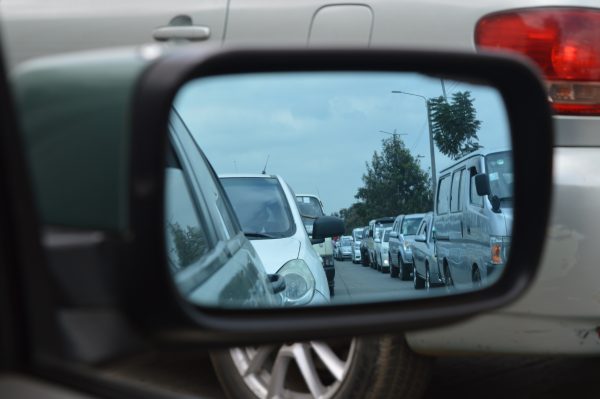 Los conductores de automóviles ven el tráfico desde el espejo retrovisor.