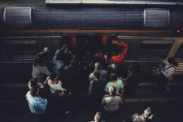 crowds of people trying to get on to a train