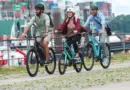 trīs cilvēki brauc ar elektriskajiem velosipēdiem