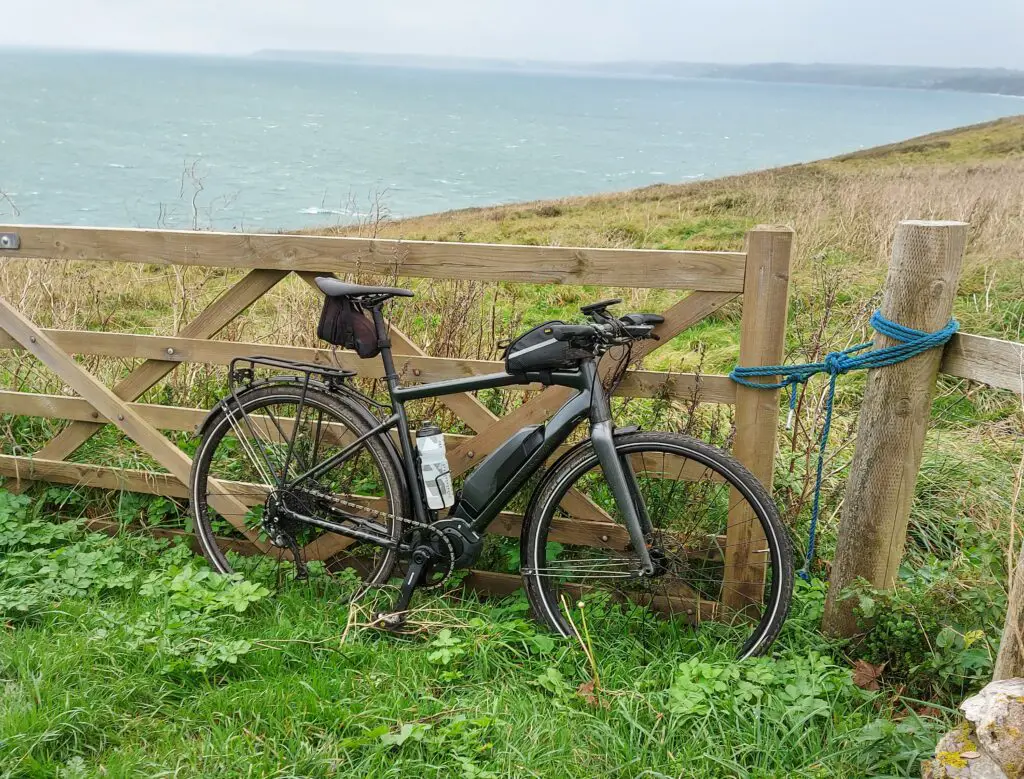 Riding an E-Bike in Cornwall - A Comprehensive Guide 2 vitus mach e pictured by a gate overlooking the sea