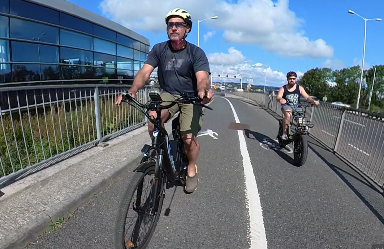 2 muži jazdiaci na e-bicykloch cez most Časté otázky o elektrických bicykloch